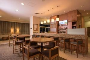 um restaurante com mesas e cadeiras e um bar em Hampton by Hilton Guadalajara Expo em Guadalajara