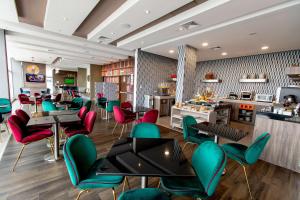 um restaurante com mesas e cadeiras verdes e vermelhas em Hampton By Hilton Lima San Isidro em Lima