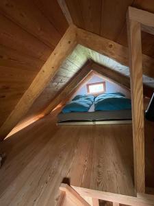 uma cama no sótão de uma casa de madeira em Chalet SOLE em Bosco Gurin