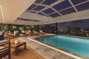 a swimming pool in a hotel with a view of the city at DoubleTree by Hilton Lima Miraflores El Pardo in Lima