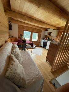 uma sala de estar com um sofá branco e uma cozinha em Chalet SOLE em Bosco Gurin