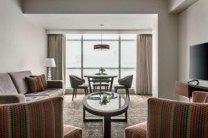 sala de estar con sofá y mesa con sillas en DoubleTree by Hilton Lima Miraflores El Pardo, en Lima