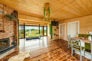 a living room with a fireplace and a table and chairs at Sweet Retreat Vlădeasa in Rogojel