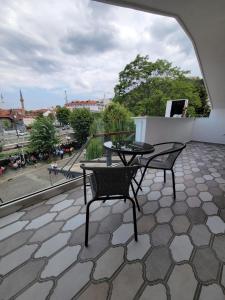 patio con mesa y sillas en el balcón en Nam Hotel, en Prizren