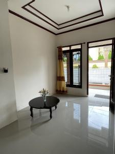 ein Wohnzimmer mit einem Tisch und einem Fenster in der Unterkunft Mawar Homestay in Banda Aceh