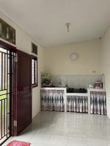 Cette chambre comprend une cuisine équipée de plaques de cuisson. dans l'établissement Mawar Homestay, à Banda Aceh