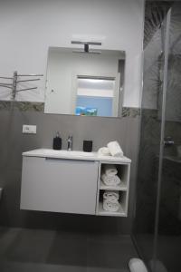 ein Badezimmer mit einem weißen Waschbecken und einem Spiegel in der Unterkunft Casa Vacanza Da Angela & Corrado in Pozzallo