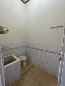 a bathroom with a toilet and a bath tub at Mawar Homestay in Banda Aceh