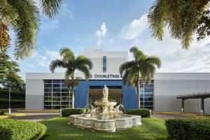 a fountain in front of a building with palm trees at DoubleTree by Hilton Managua in Managua