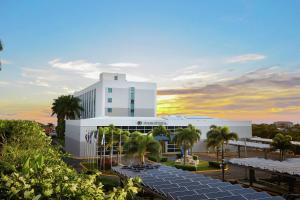 ein großes weißes Gebäude mit Palmen davor in der Unterkunft DoubleTree by Hilton Managua in Managua