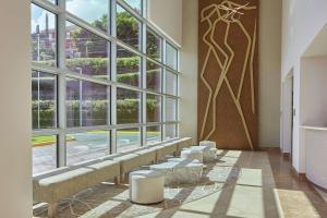 a waiting room with a large window and benches at DoubleTree by Hilton Managua in Managua