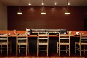 a bar with four chairs at a counter with a toaster at DoubleTree by Hilton Managua in Managua