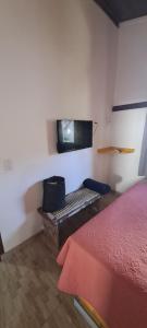 um quarto com uma cama e uma televisão na parede em Porto do Sol - Chalé 07 em Pipa