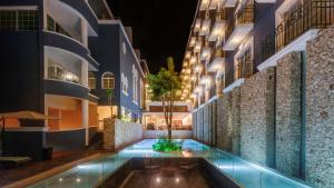a courtyard of a building with a tree in the middle at Villa Mercedes Curio Collection By Hilton in Mérida