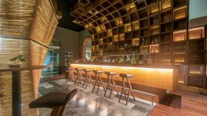 a bar with a bunch of stools in a room at Villa Mercedes Curio Collection By Hilton in Mérida