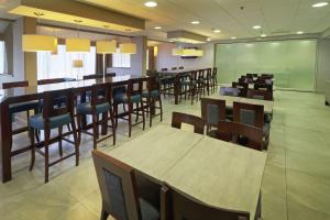 un comedor con mesas y sillas y una pizarra en Hampton Inn Monterrey-Airport, en Monterrey