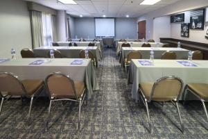 una sala de conferencias con mesas, sillas y una pantalla en Hampton Inn Monterrey-Airport en Monterrey