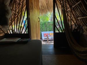 a room with a hammock and a door to a patio at Calypso cabanas in El Paredón Buena Vista