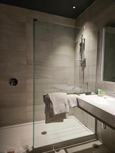 a bathroom with a shower and a sink at Grand Hotel TiMES Blainville-Mirabel in Blainville
