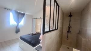 a bedroom with a bed and a shower and a window at Gîte 4/6 personnes La mélodie du bonheur in Habas