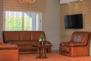 - un salon avec un canapé, deux chaises et une télévision dans l'établissement Villa in Rabat, 