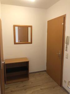 Zimmer mit einem Spiegel, einem Tisch und einer Tür in der Unterkunft Apartment für Monteure in Leipzig