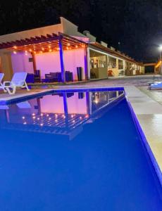 a swimming pool in front of a house at night at Condomínio Dunas Residence - Casa 7 e Casa 10 - Santo Amaro - MA in Santo Amaro