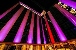 Hilton Garden Inn Santiago Del Estero - 4 Estrellas في سانتياغو ديل إستيرو: مبنى به أضواء وردية وأرجوانية