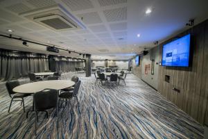 a conference room with tables and chairs and a flat screen tv at Hilton Garden Inn Santiago Del Estero - HILTON HOTELS in Santiago del Estero