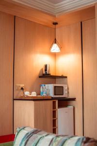a small kitchen with a microwave on a counter at Marcsons Hotels and Resorts in Limbe
