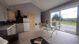 a kitchen with a table and a kitchen with a window at Gîte 4/6 personnes La mélodie du bonheur in Habas