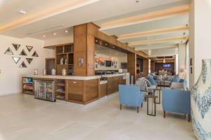 une salle à manger avec des chaises bleues et un bar dans l'établissement Hampton Inn & Suites by Hilton Salamanca Bajio, à Salamanca