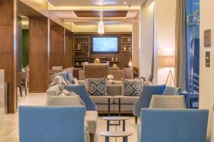 une salle d'attente avec des canapés, des chaises et une télévision dans l'établissement Hampton Inn & Suites by Hilton Salamanca Bajio, à Salamanca