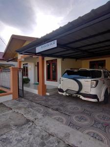 un'auto parcheggiata di fronte a un edificio di Mawar Homestay a Banda Aceh