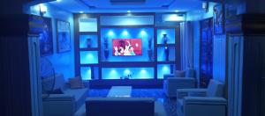 ein Wohnzimmer mit blauen Lichtern und einem TV in der Unterkunft De-Convenant Apartment in Abuja