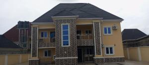 a large yellow house with a black roof at De-Convenant Apartment in Abuja