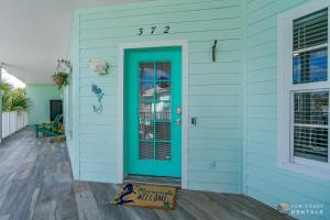 een blauwe voordeur van een huis met een blauwe deur bij Mermaid Themed Apartment with Private Balcony ON Flagler Avenue! Stroll to the Beach! in New Smyrna Beach