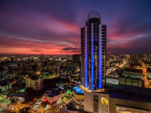 wysoki budynek z niebieskimi światłami w nocy w obiekcie Embassy Suites by Hilton Santo Domingo w mieście Santo Domingo