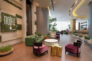 a lobby of a hotel with chairs and a table at Embassy Suites by Hilton Santo Domingo in Santo Domingo