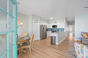 een keuken en een woonkamer met een tafel en een eetkamer bij Mermaid Themed Apartment with Private Balcony ON Flagler Avenue! Stroll to the Beach! in New Smyrna Beach