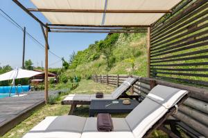 a pergola with a table and chairs and a pool at La Tana dello Scoiattolo - Adults Only in Murazzano