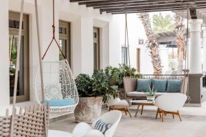 een terras met stoelen en een schommel bij Hilton Grand Vacations Club La Pacifica Los Cabos in Cabo San Lucas