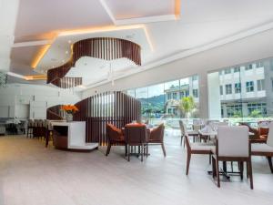 a dining room with tables and chairs and windows at Hilton Garden Inn Santa Ana, San Jose in San José