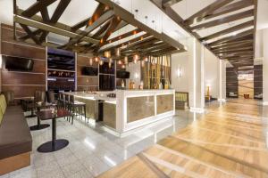 a bar in a restaurant with wooden floors and ceilings at Hilton Garden Inn San Jose La Sabana, Costa Rica in San José