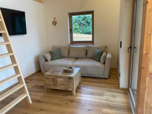 a living room with a couch and a table at Ferienhäuser Koralpe unicorn village in Wolfsberg