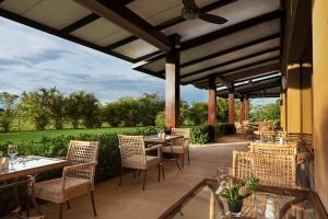 a patio with tables and chairs with a view at Hilton Garden Inn Guanacaste Airport in Liberia