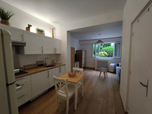 a kitchen with white cabinets and a table with chairs at Studio Cap Martin in Roquebrune-Cap-Martin