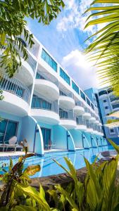 a hotel with a swimming pool in front of a building at Harbor Club St Lucia, Curio Collection by Hilton in Gros Islet +47 photos