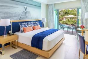 um quarto com uma cama grande e uma varanda em Harbor Club St Lucia, Curio Collection by Hilton em Gros Islet