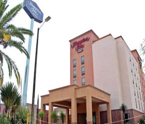 a building with a sign on the side of it at Hampton by Hilton Saltillo Zona Aeropuerto in Saltillo